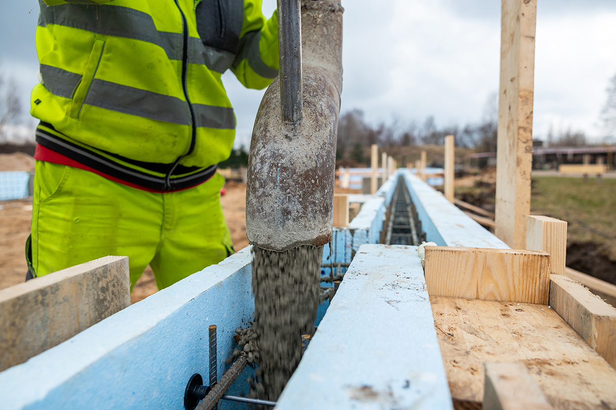 Construction Worker Precisely Operating Concrete Pump at New Bui